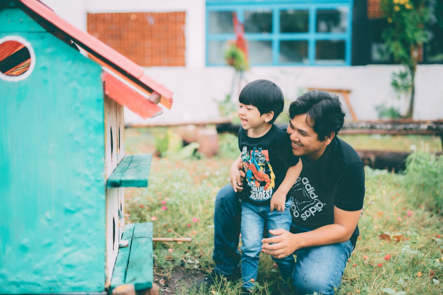 Father and young son exploring birdhouse outdoors — family skills passed down